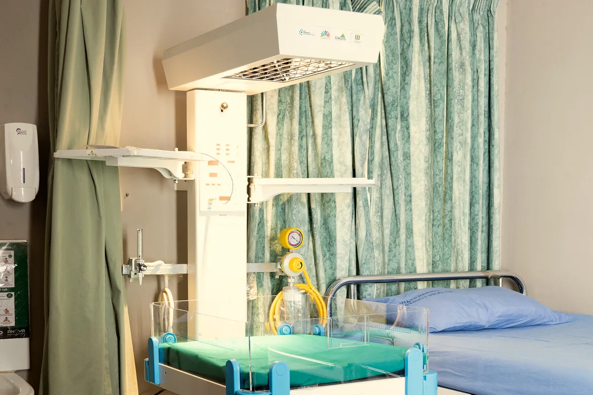 A newborn resuscitation warmer and hospital bed in a maternity ward supported by Dikuno