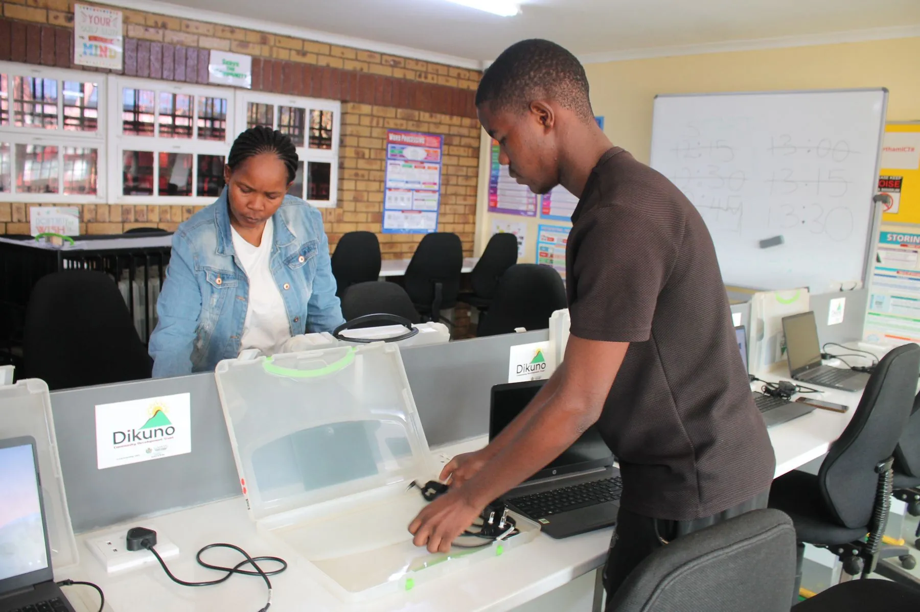 A young man and a woman setting up computers at the Northam ICT Centre