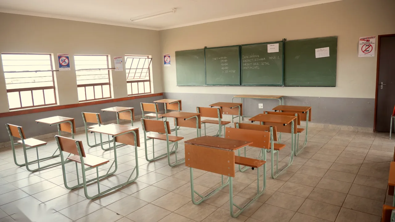 A new classroom with learner desks, chalkboards and tiled floor
