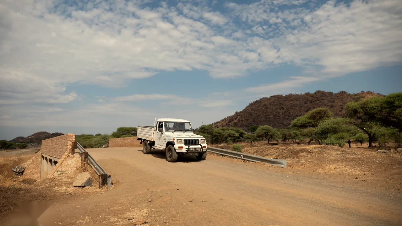 A vehicle crossing the new bridge with hills in the background